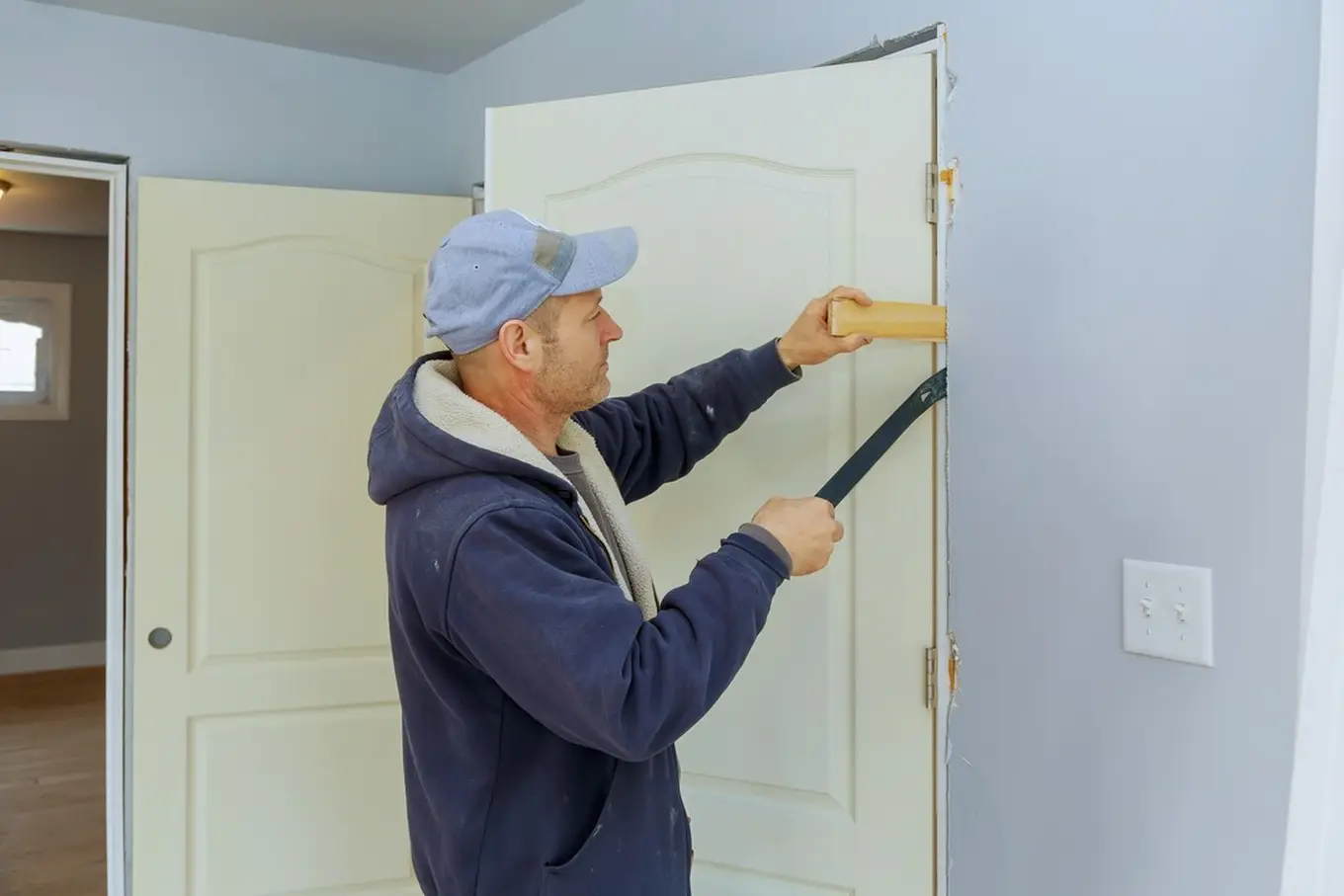 mężczyzna montuje nowe drzwi